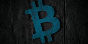 Niebieski symbol Bitcoina wyśrodkowany na ciemnym, teksturowanym tle o pogniecionym i lekko postarzanym wyglądzie.