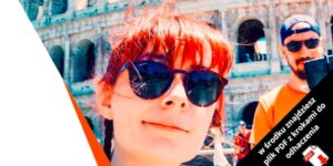 Kobieta w rudych włosach i okularach przeciwsłonecznych robi sobie selfie przed Koloseum, a w tle uśmiecha się mężczyzna w okularach przeciwsłonecznych i pomarańczowej koszuli. Przekątny czarny baner z polskim tekstem i ikoną PDF jest nałożony w rogu.