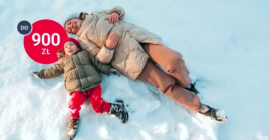 Kobieta i dziecko w zimowych płaszczach i butach leżą na plecach na śniegu, uśmiechając się. Czerwony okrąg z białym napisem "DO 900 ZŁ.
