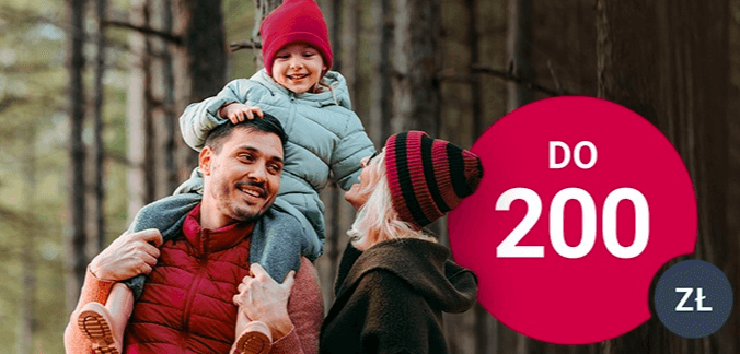 Uśmiechnięta rodzina cieszy się spacerem po lesie. Dorosły mężczyzna niesie na ramionach dziecko, a obok stoi dorosła kobieta. Duże różowe koło wyświetla "DO 200 zł".