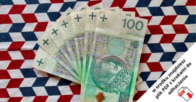 Kilka banknotów o nominale 100 złotych rozłożonych na tkaninie z czerwonym, białym i niebieskim wzorem geometrycznym. W rogu znajduje się polski tekst o pliku PDF i czerwona ikona znacznika wyboru.